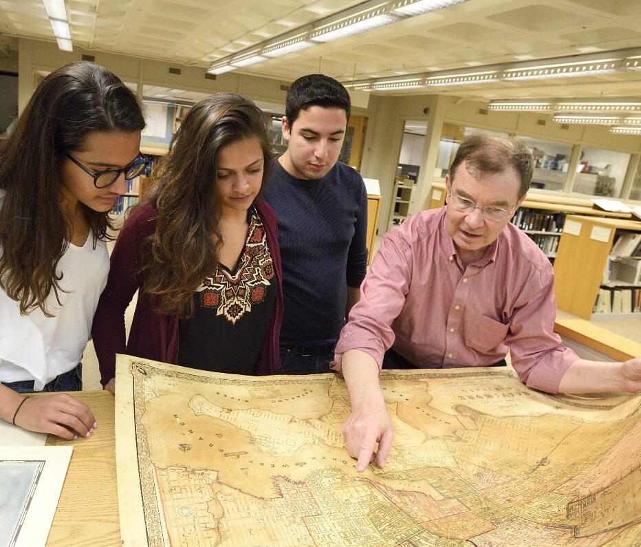A group of students looking over a large map.